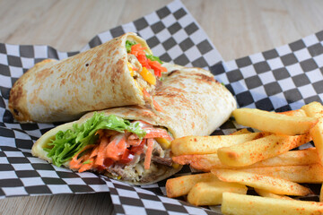 
Fast Food, Mexican burritos with meat and vegetables, accompanied by French fries, decorated with black checkered napkin