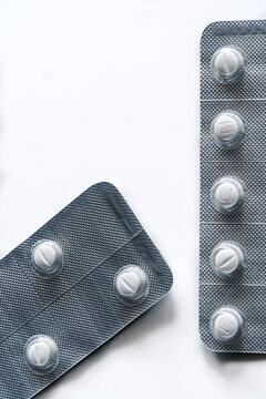 Closeup top view of full frame background of various white pills in plastic blisters