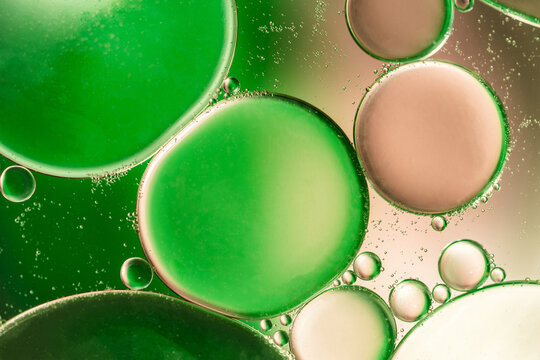 Closeup of abstract background with round shaped cells of vaccine of different sizes illuminated by colorful light