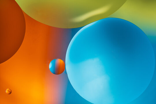 Closeup of abstract background with round shaped cells of vaccine of different sizes illuminated by colorful light
