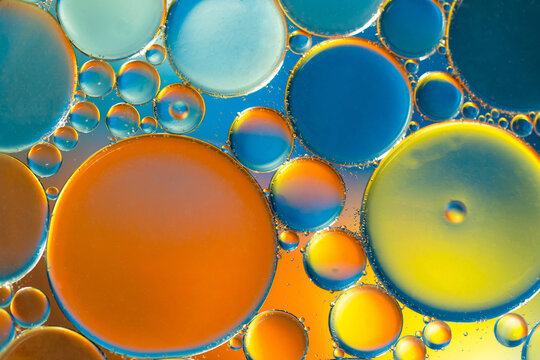 Closeup of abstract background with round shaped cells of vaccine of different sizes illuminated by colorful light