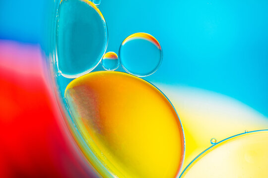 Closeup of abstract background with round shaped cells of vaccine of different sizes illuminated by colorful light