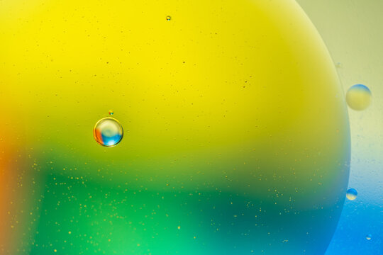 Closeup of abstract background with round shaped cells of vaccine of different sizes illuminated by colorful light