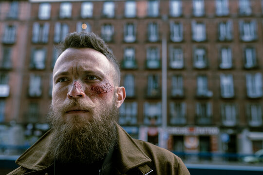 Hipster man with beard and cinema makeup posing on the street
