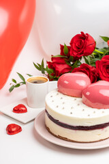 Obraz na płótnie Canvas mousse cake in white glaze with two big pink hearts, a cup of coffee and a bouquet of red roses