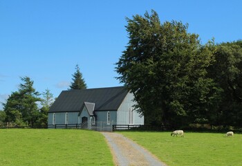 Fototapeta na wymiar Lurganboy Chapel-of-ease , County Leitrim, built in 1862, a Church of Ireland church made of corrugated iron sheets, photographed here in summertime against backdrop of blue sky 
