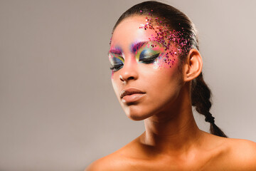 Portrait of brunette woman with ponytail and makeup eyes looking down