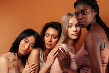 young pretty asian, caucasian, afro woman posing cheerful together on brown background, lifestyle diverse nationality people concept