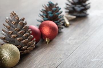 Natural oak tree cones on a wooden deck with glittering ornaments around