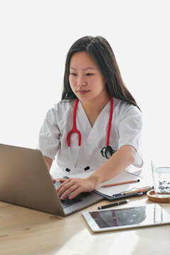 Stock photo of asian female doctor working from home.
