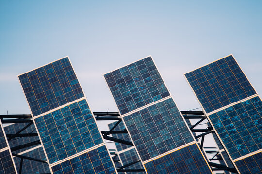 Modern solar panels installed in field against cloudy sky in photovoltaic power station
