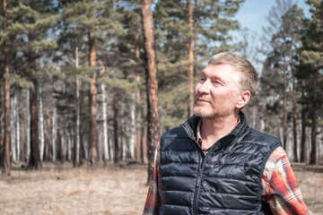 Portrait of a handsome unshaven middle-aged man in the park. Adult man in shirt and vest outdoors. Copy space.