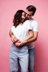 Fototapeta premium young cheerful caucasian couple together having fun on pink background, guy ang girl modern relationship, lifestyle people concept