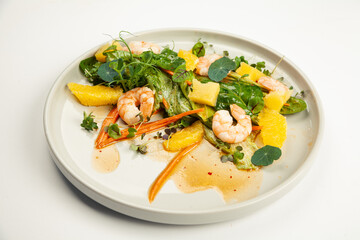Shrimp salad in soy-ginger dressing on a plate. Ingredients Iceberg lettuce, shrimp, spinach, orange, pineapple, carrot, soy-ginger dressing. For restaurant menu