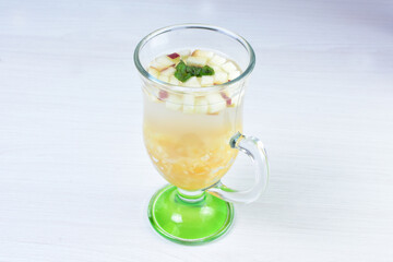 Colorful italian sodas with chopped fruits on white wooden background