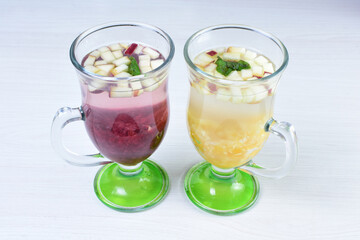 Colorful italian sodas with chopped fruits on white wooden background