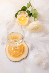 Glass of white wine, rose and candle on a white background. 8th march and valentine's day concept