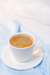 white cup of coffee on blue cloth