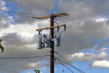 Electricity pylon and power lines under cloudy sky