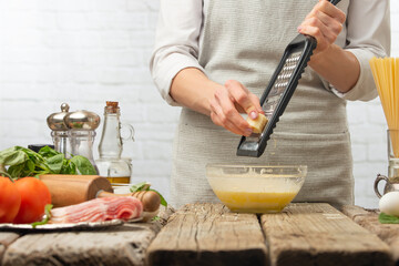 The chef prepares cheese-creamy sauce for the preparation of Italian pasta carbonara. Gastronomy and culinary, restaurant, hotel business. Recipe book