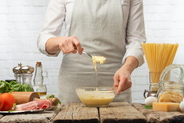 The chef prepares a sauce with creamy parmesan cheese. Freezing in motion. Ingredients, menus and cooking. Recipe book and restaurant business