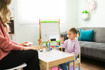 Female tutor teaching an adorable preschooler basic math