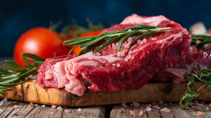 Fresh piece of beef steak with rosemary on the background of the ingredients.Recipe book, dishes with meat .Advertising butcher shops and meat markets banner