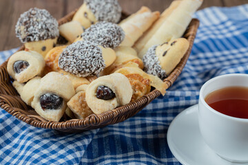 Variety of cookies in the platter with a cup of tea aside