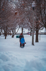 Fototapeta na wymiar parent and child walking in the snow