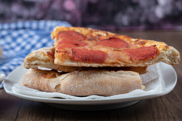 Pepperoni pizza slices in a white ceramic plate