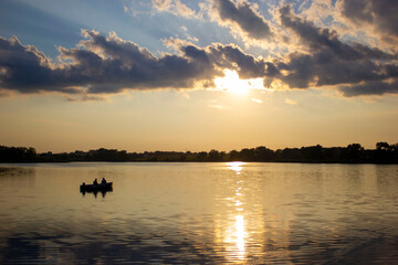 Fishing boat on lake at sunset
