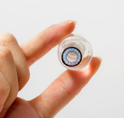 cosmetic contact lenses in bottle with  hand