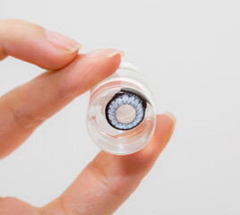 cosmetic contact lenses in bottle with  hand