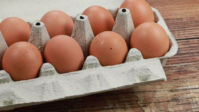 boite de dix oeufs sur une table en bois