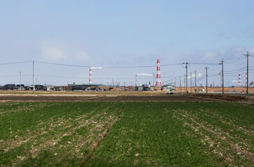 Fototapeta na wymiar 工業団地の煙突と農地の風景