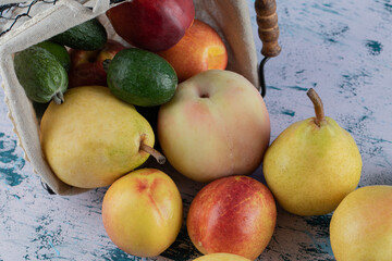 Mixed autumn fruits out of a metallic basket