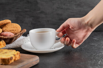 Cookies on a wooden platter served with a cup of tea