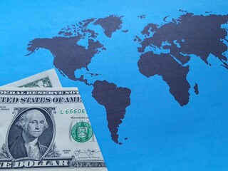 american one dollar bill and background with a world map in black and blue