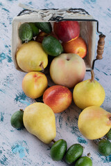 Mixed autumn fruits out of a metallic basket