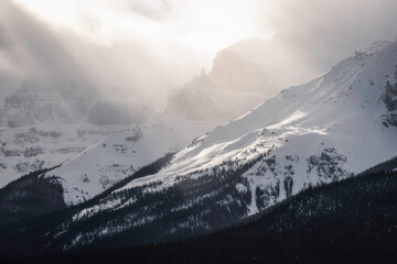 Spectacular light shining through the Winter atmosphere upon the Canadian Rockies in Banff National Park.