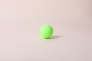 a golf ball of various colors with a pink background