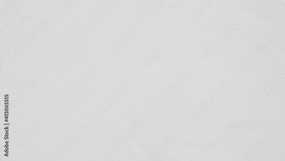 Poster close up top view of water droplets falling into the water and separate splashes of water on gray ba