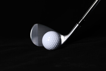 Black background, golf balls and clubs.