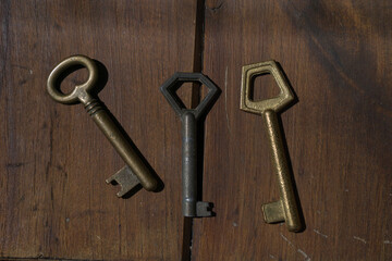 Set of old door keys on wood.