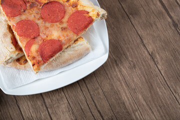 Pepperoni pizza slices in a white ceramic plate