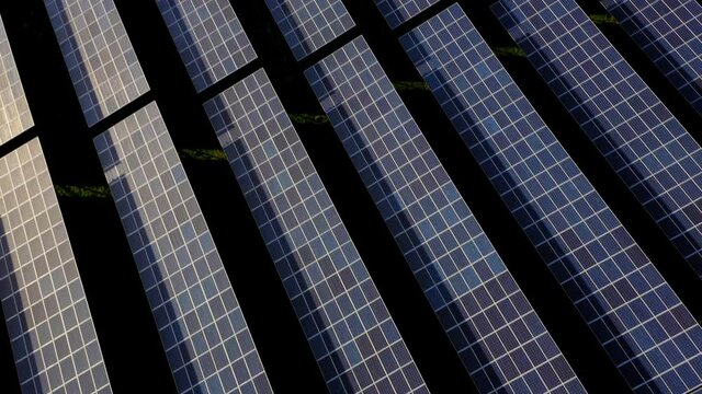 Long low drone orbit above large solar panel farm in Wales.
