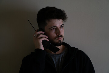 Handsome young man making a call from an old cell phone