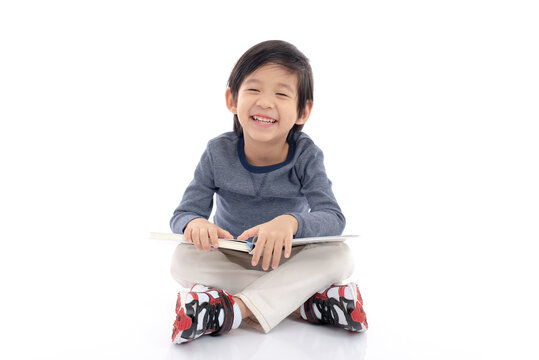 Cute asian boy reading a book on white background isolated