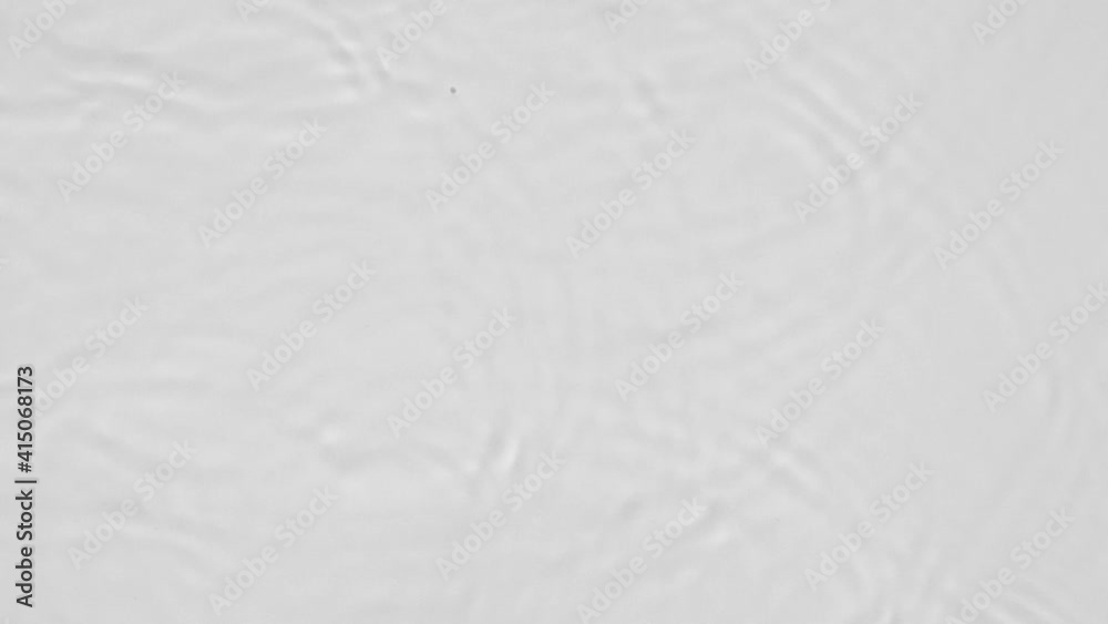 Poster Close up top view of water droplets falling into the water and separate splashes of water on gray background in 4k slow motion.