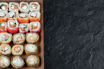 Hot sushi set on a wooden board with mixed ingredients